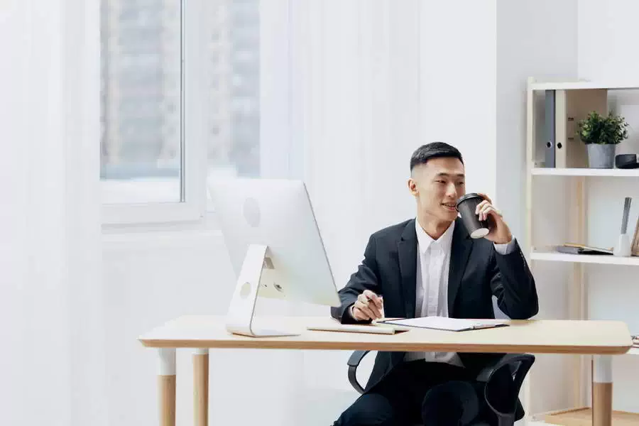 Man Works in Office Holding Coffee